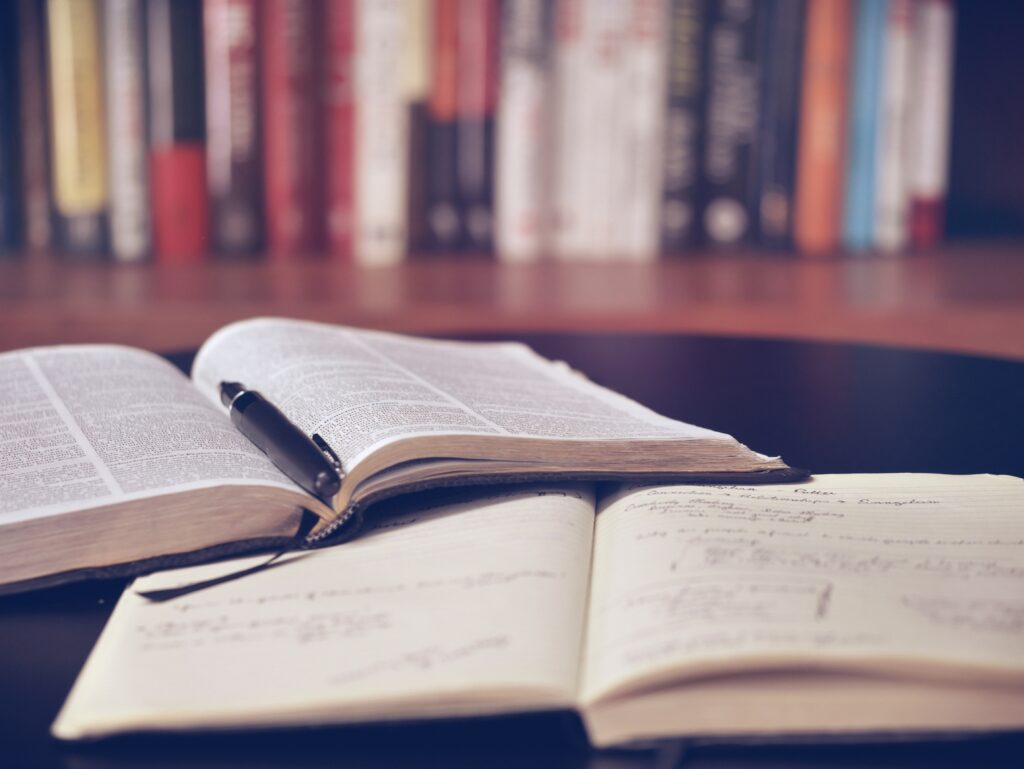 An open book and handwritten notes on a study desk